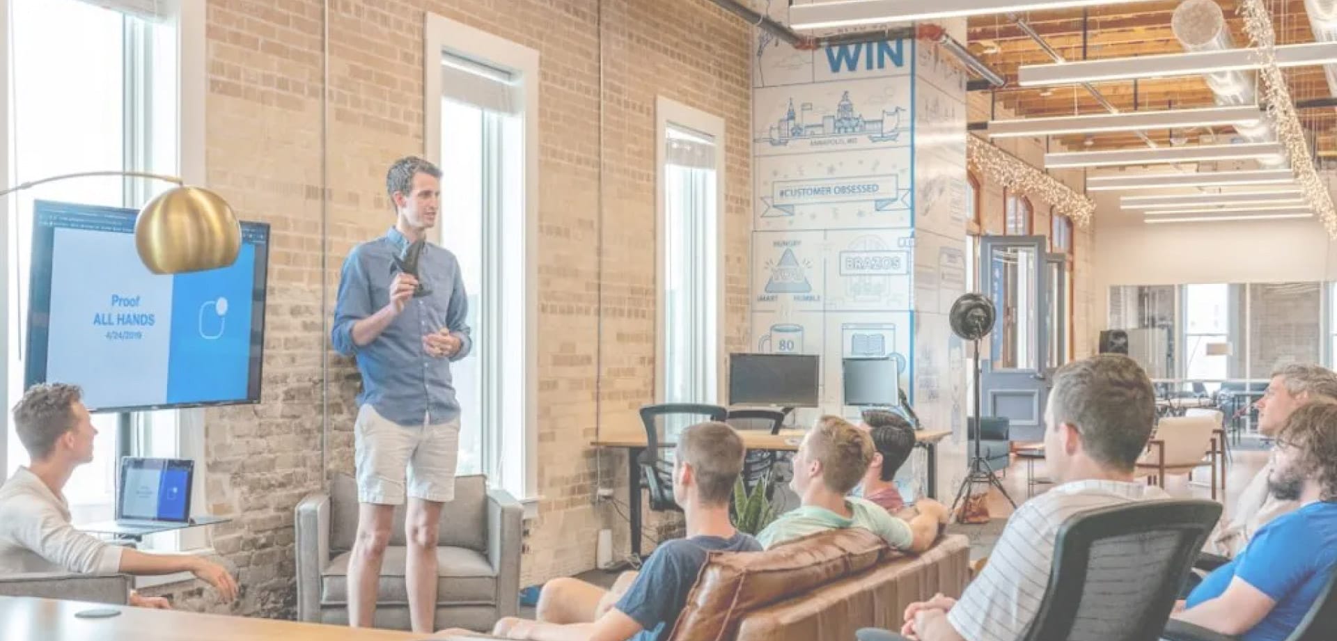 boldtek-background Background image of a man speaking in front of colleagues for BoldTek